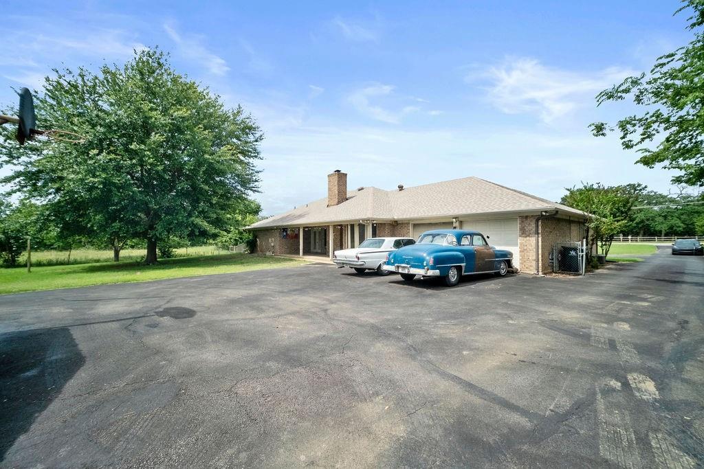 6939 Calender Road Arlington, TX 76001 - Photo 8 of 40 View of front facade with driveway, a chimney, an attached garage, and brick siding