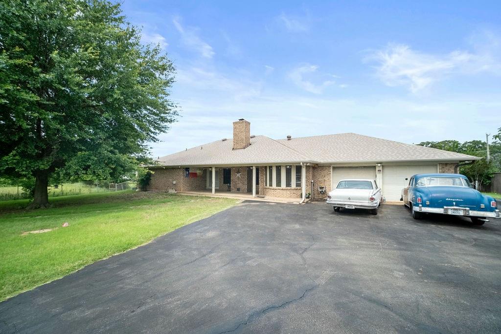 6939 Calender Road Arlington, TX 76001 - Photo 9 of 40 Single story home with driveway, a garage, a front yard, a chimney, and brick siding
