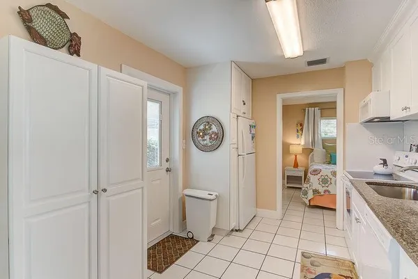 a bathroom with a granite countertop toilet a sink and a window
