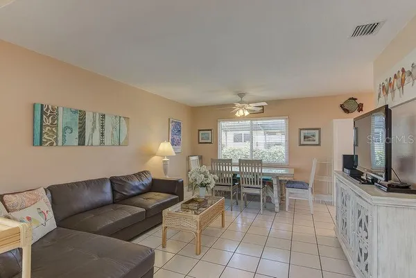 a living room with furniture a flat screen tv and a window