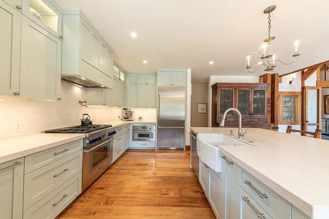 a large kitchen with stainless steel appliances and white cabinets