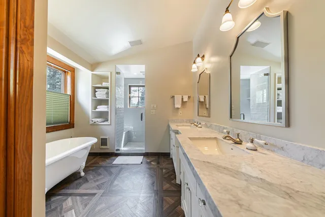a spacious bathroom with a tub sink and mirror