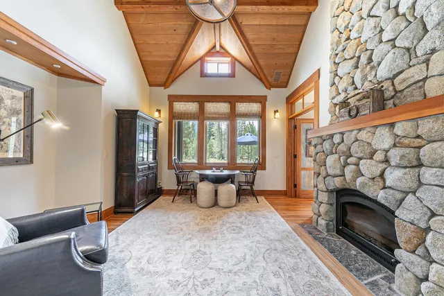 a living room with furniture a fireplace and a floor to ceiling window