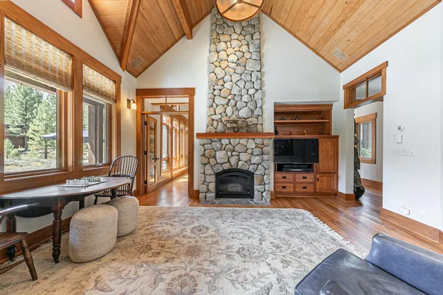 a living room with furniture a fireplace and a floor to ceiling window