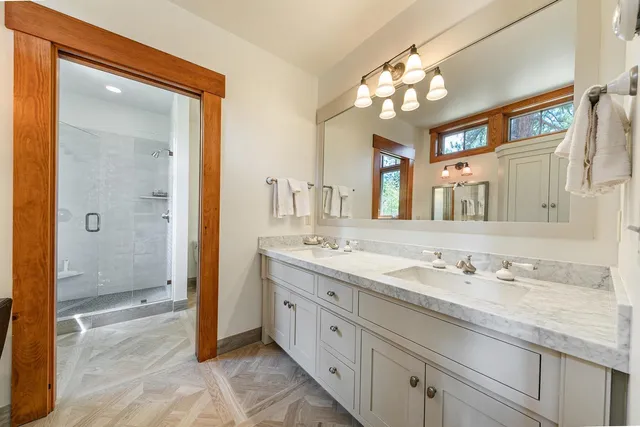 a spacious bathroom with a granite countertop sink mirror and a shower