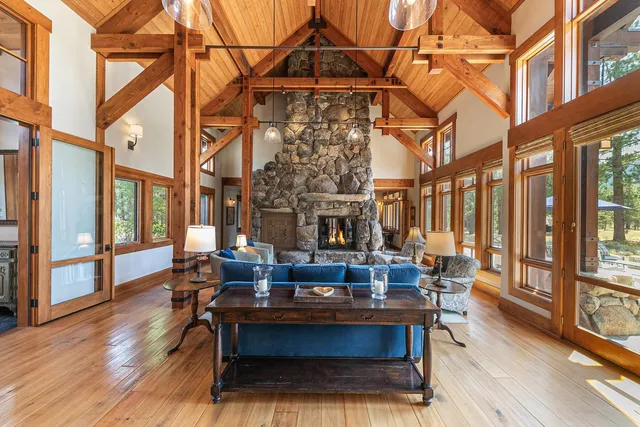 a living room with furniture a large window and wooden floor