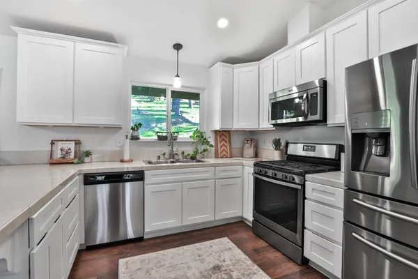 a kitchen with stainless steel appliances a stove sink microwave and refrigerator