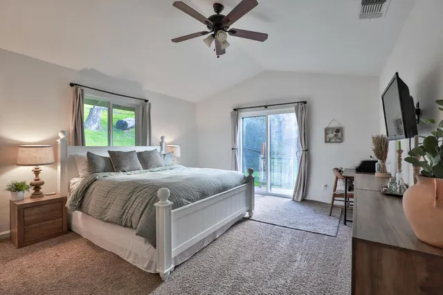 a bedroom with a bed a couch and a flat tv screen