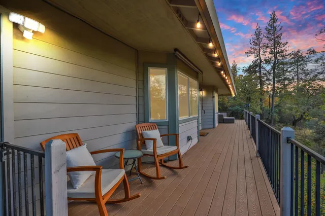a balcony with chairs and wooden fence