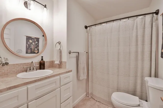 a bathroom with a toilet sink vanity and mirror