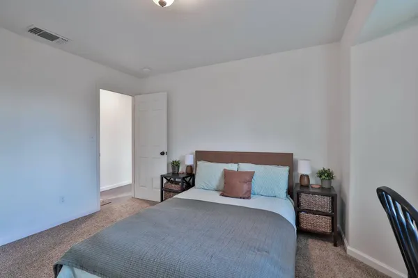 a bedroom with a bed and a potted plant