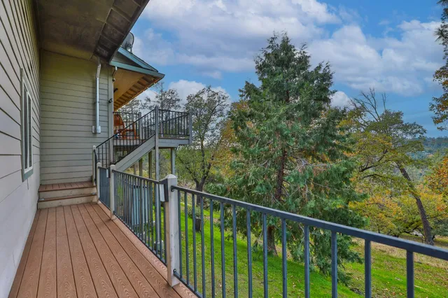 a view of a balcony with wooden floor and fence
