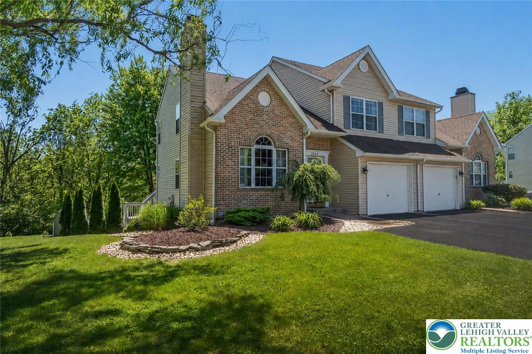 2314 Red Maple Drive Coplay, PA 18037 - Photo 4 of 73 A classic facade combining brick and siding, featuring a garage and verdant surroundings.