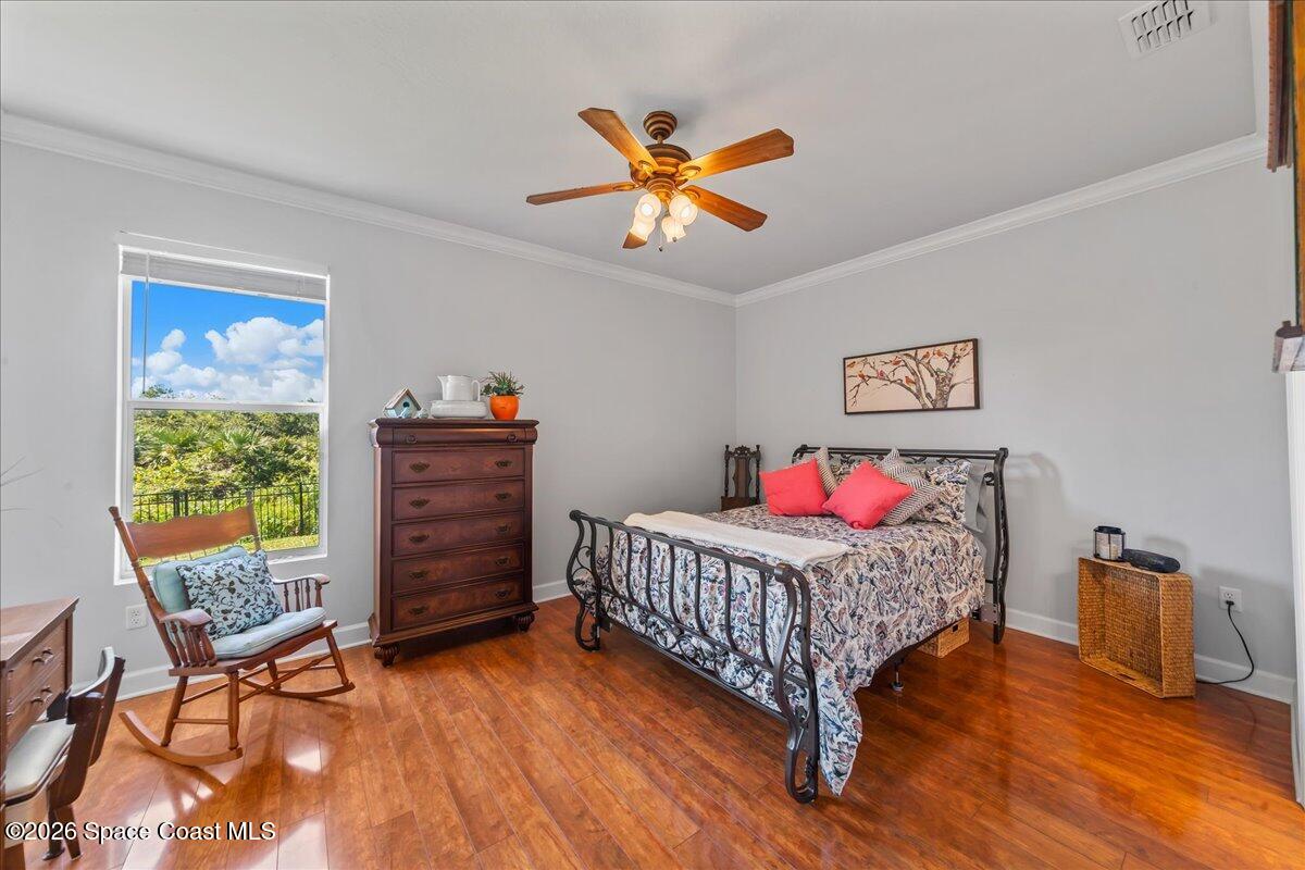 3210 Arden Circle Melbourne, FL 32934 - Photo 16 of 42 a bedroom with a bed and a chandelier