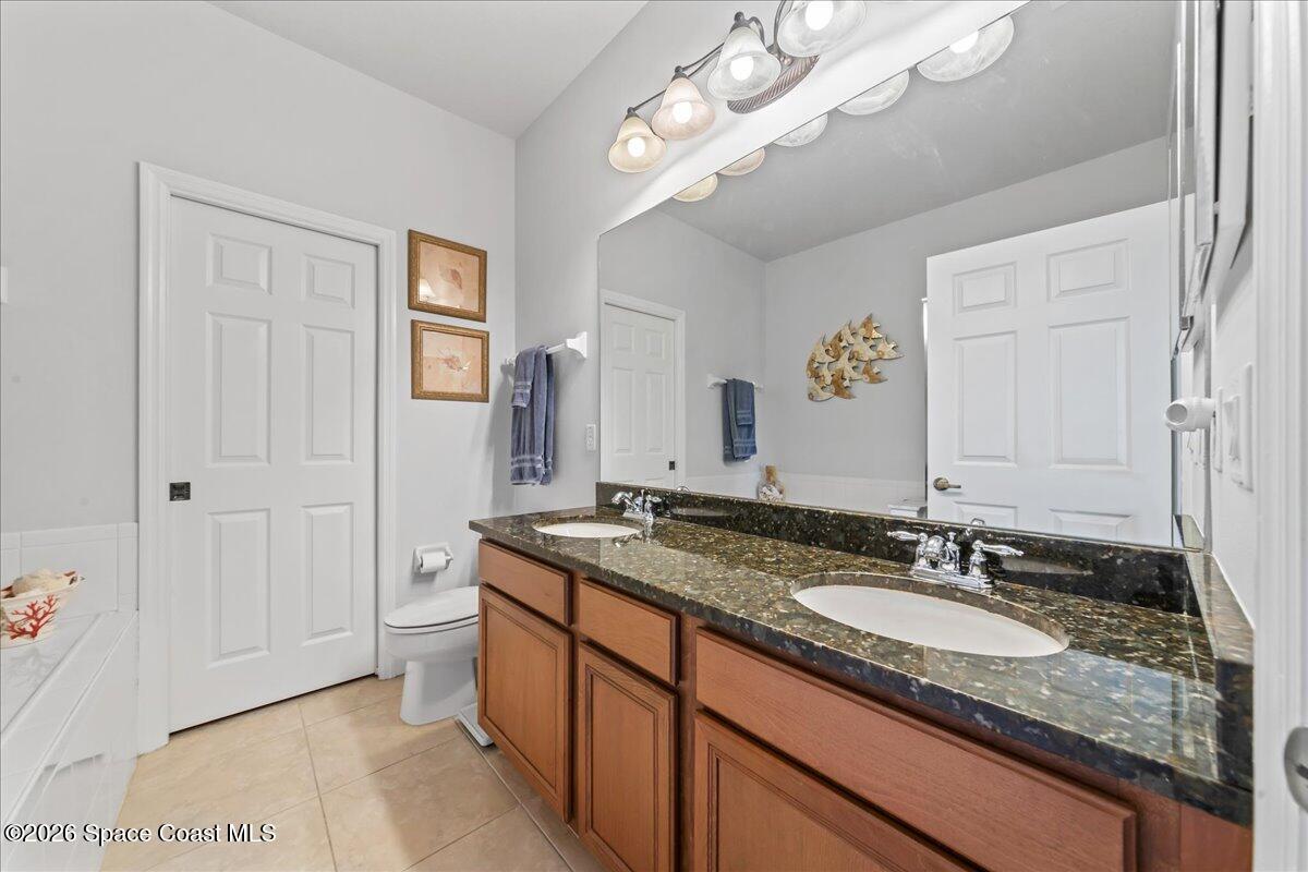 3210 Arden Circle Melbourne, FL 32934 - Photo 18 of 42 a bathroom with a granite countertop sink a light fixture and a mirror