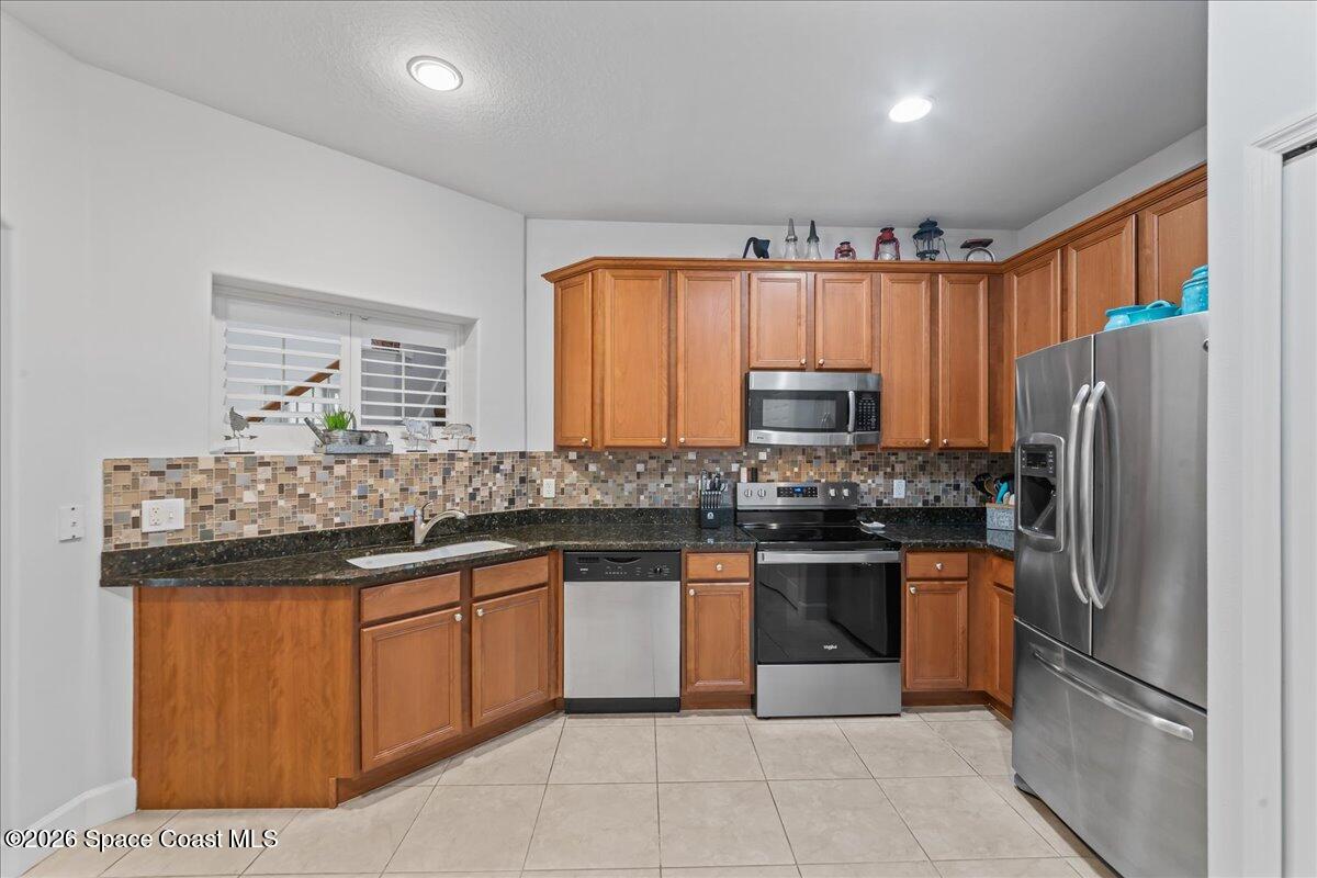 3210 Arden Circle Melbourne, FL 32934 - Photo 5 of 42 a kitchen with stainless steel appliances granite countertop a stove top oven a refrigerator and a sink