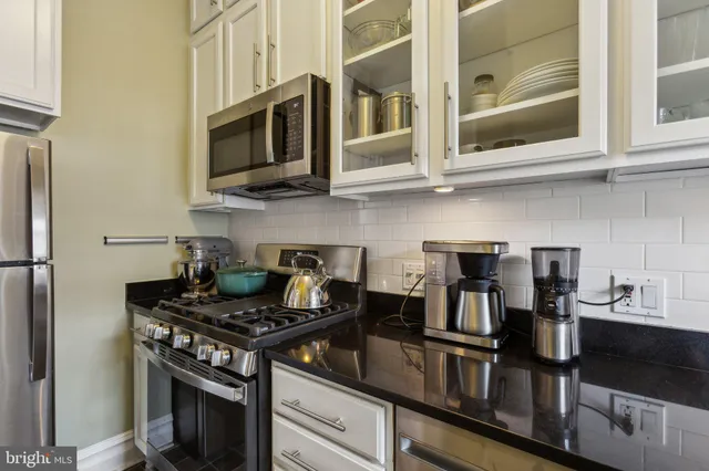 a kitchen with stainless steel appliances granite countertop a stove and a microwave