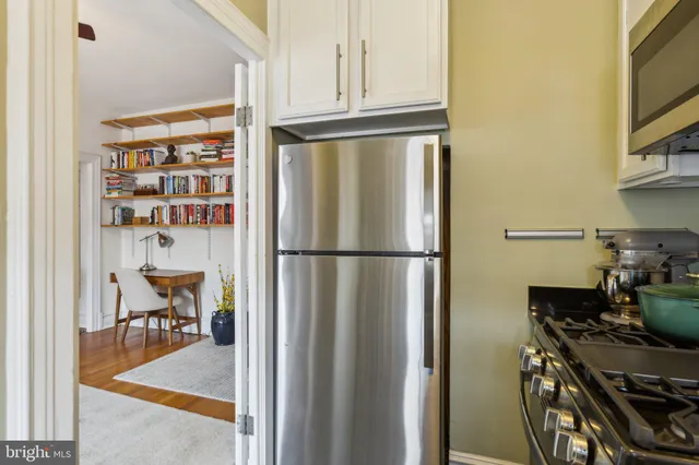 a kitchen with stainless steel appliances granite countertop a refrigerator and a stove