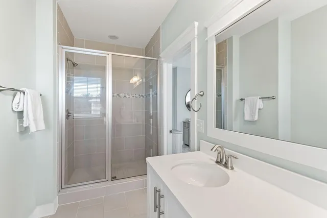 a bathroom with a shower sink vanity and mirror