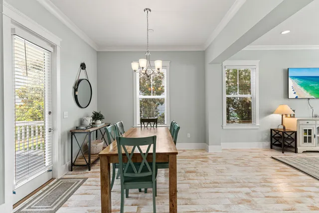 a dining room with furniture a chandelier and wooden floor
