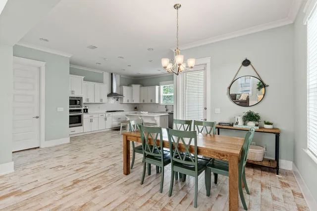 a view of a dining room with furniture a chandelier and wooden floor