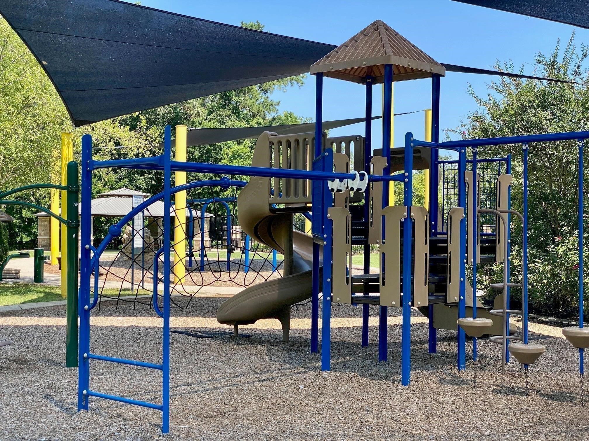 438 Vane Way Crosby, TX 77532 - Photo 14 of 21 This photo features a vibrant playground with slides, climbing structures, and shade canopies, surrounded by greenery—ideal for families seeking nearby recreational spaces.