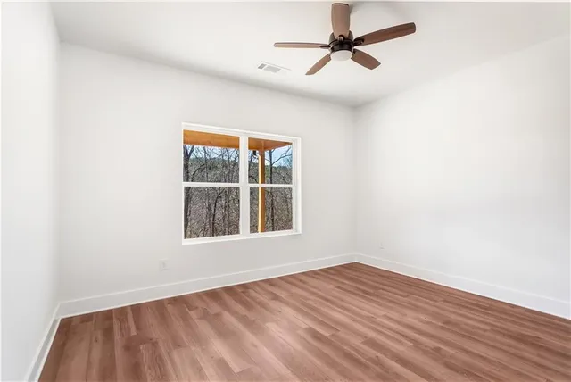 an empty room with a window and a ceiling fan