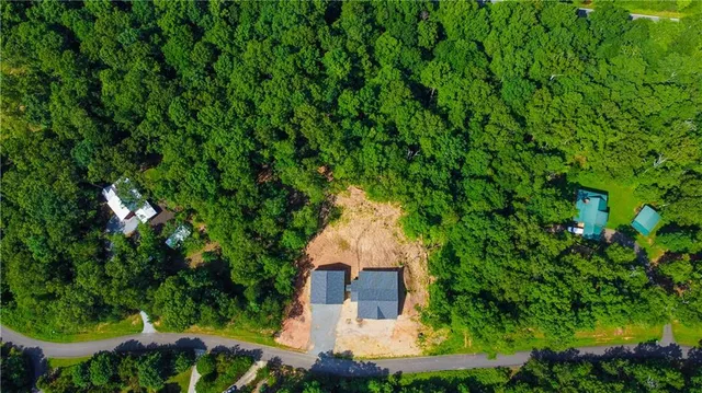 an aerial view of a house with a yard and large tree