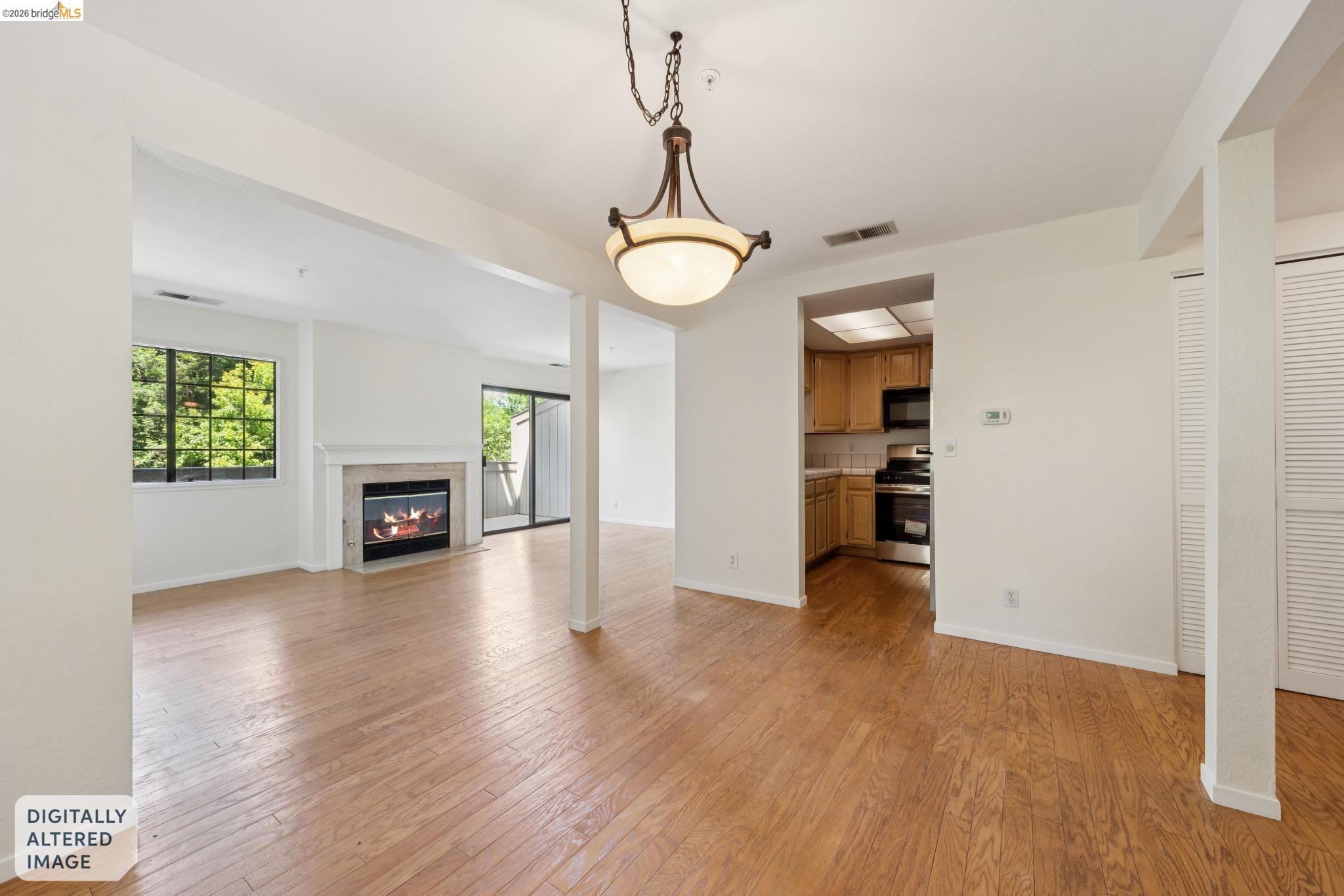 261 Redhawk Road Novato, CA 94949 - Photo 11 of 44 Bright living space featuring wood-finish flooring, a contemporary fireplace with a light-toned surround, and a large window with exterior greenery