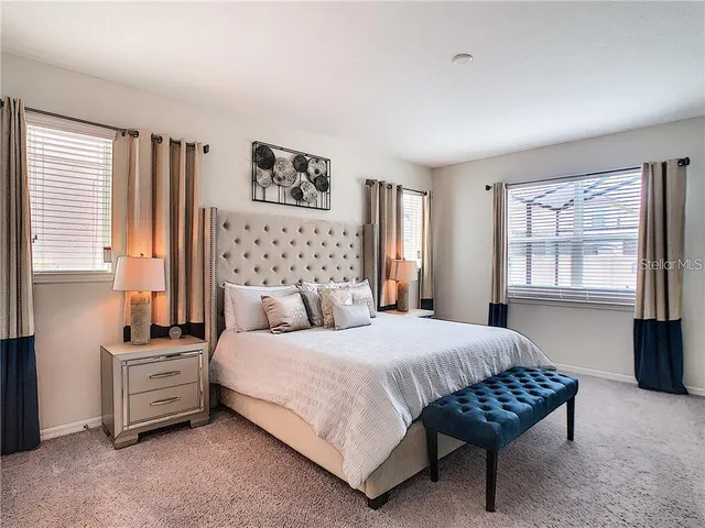 a bedroom with a bed next to a window with a dresser