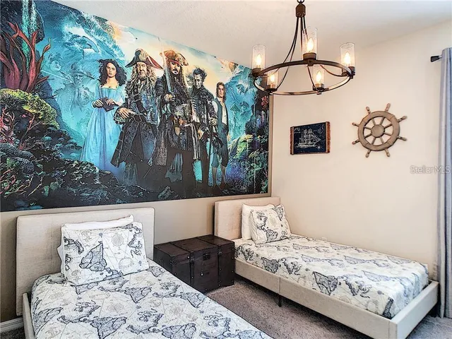 a bedroom with a bed and a chandelier