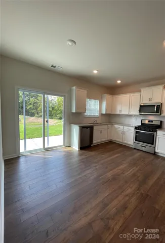 a view of kitchen with wooden floor and electronic appliances