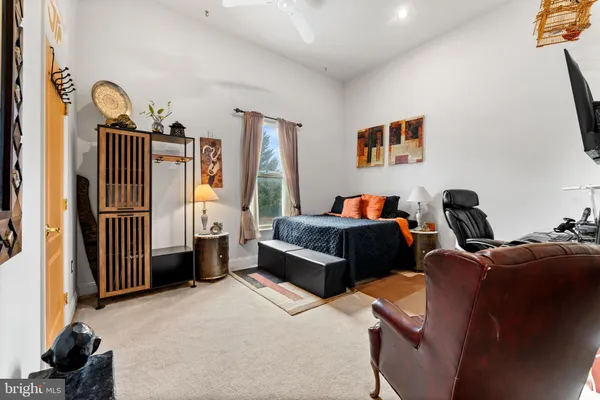 a bedroom with a bed next to a window with the view of bedroom