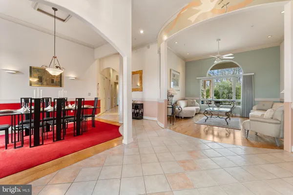 a living room with lots of furniture a dining table and a chandelier
