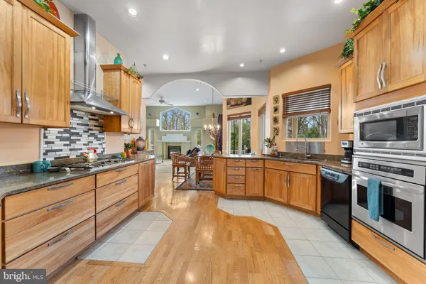 a kitchen with stainless steel appliances granite countertop a refrigerator and a stove top oven