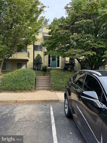 a view of a small car is parked in front of a house