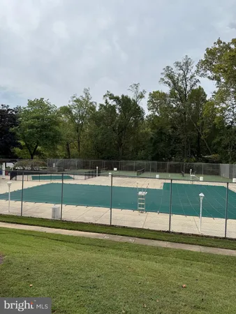 a view of house with outdoor space and trees in the background