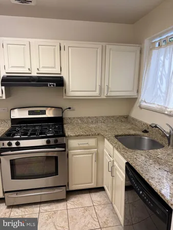 a kitchen with granite countertop white cabinets and appliances