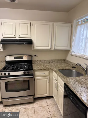 a kitchen with granite countertop white cabinets and appliances