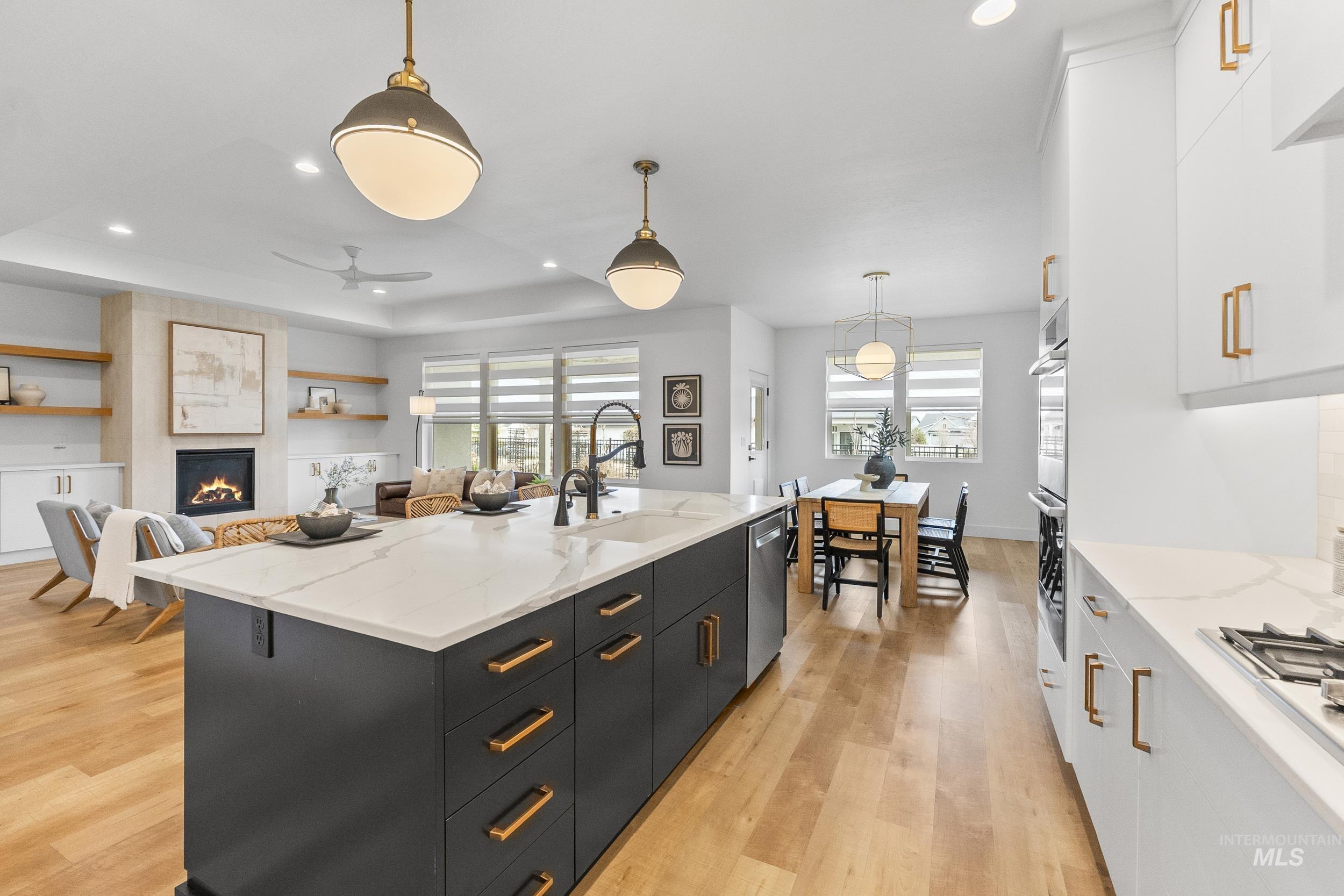 4320 South Selatir Way Meridian, ID 83642 - Photo 17 of 44 Kitchen with white cabinets up and dark island color, pendant lighting, white cabinetry, light wood-style flooring, and recessed lighting