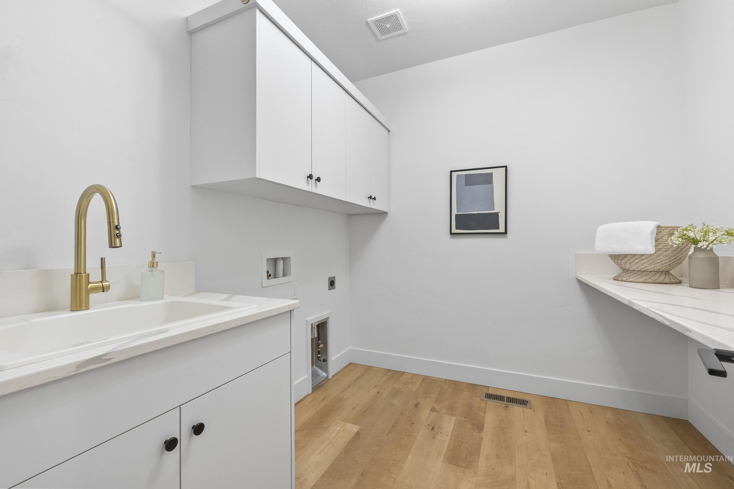 4320 South Selatir Way Meridian, ID 83642 - Photo 40 of 44 Washroom featuring cabinet space, light wood-type flooring, electric dryer hookup, and washer hookup