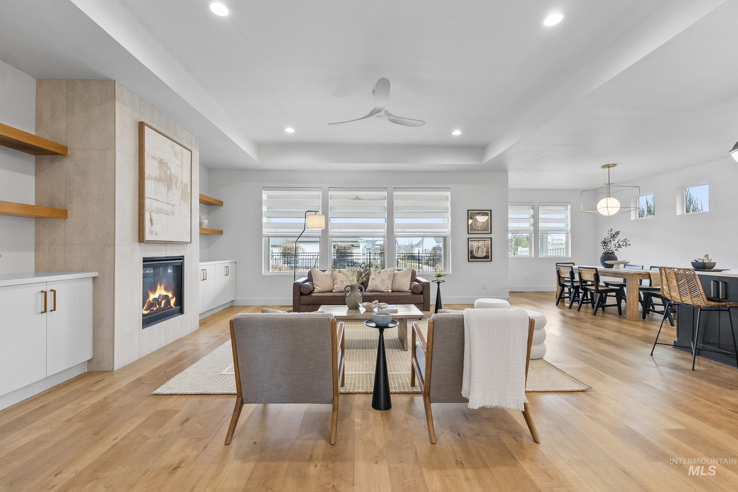 4320 South Selatir Way Meridian, ID 83642 - Photo 7 of 44 Living area featuring light wood-style floors, a tile fireplace, a tray ceiling, and recessed lighting