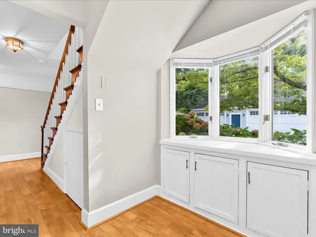 a view of a kitchen with white cabinets and a window