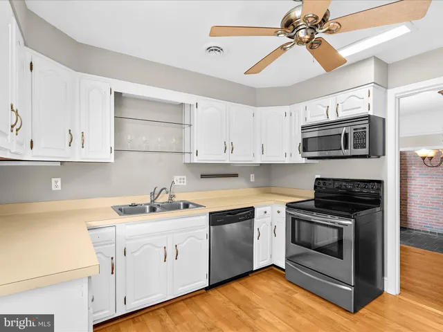 a kitchen with cabinets stainless steel appliances a sink and a counter space