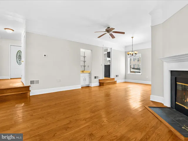 a view of empty room with wooden floor and fireplace