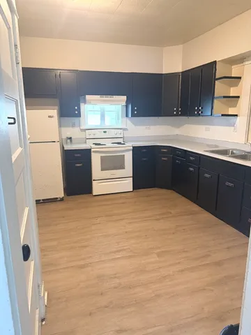 a kitchen with a cabinets and white appliances