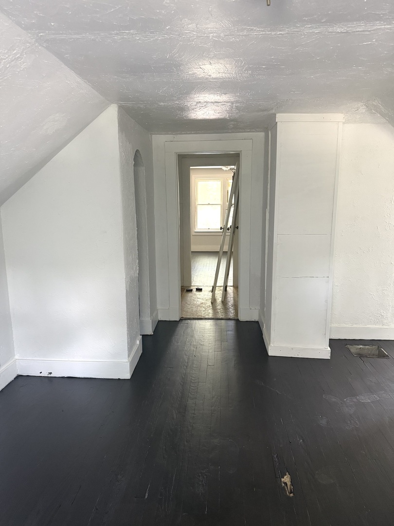 1850 East Prairie Avenue Decatur, IL 62521 - Photo 15 of 16 an empty room with wooden floor and windows with curtains