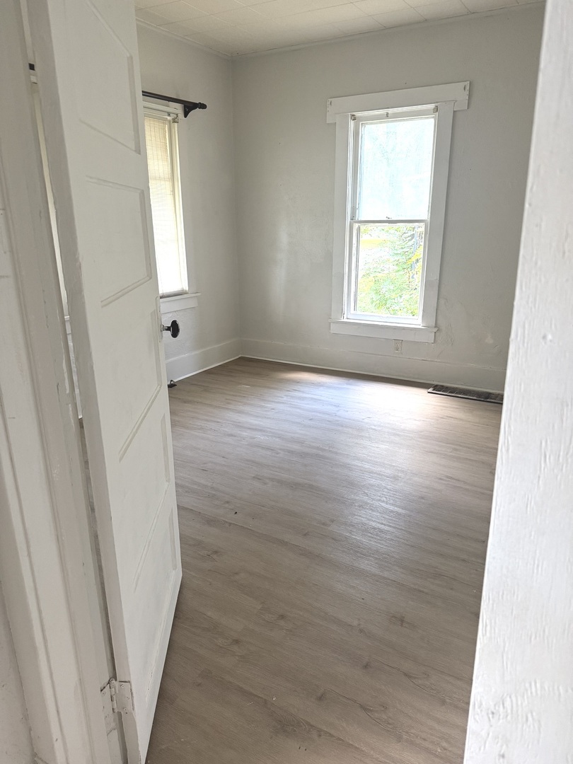 1850 East Prairie Avenue Decatur, IL 62521 - Photo 4 of 16 an empty room with wooden floor and windows