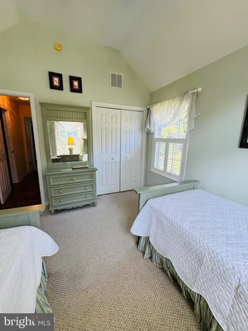 a bedroom with a bed and a flat tv screen on dresser