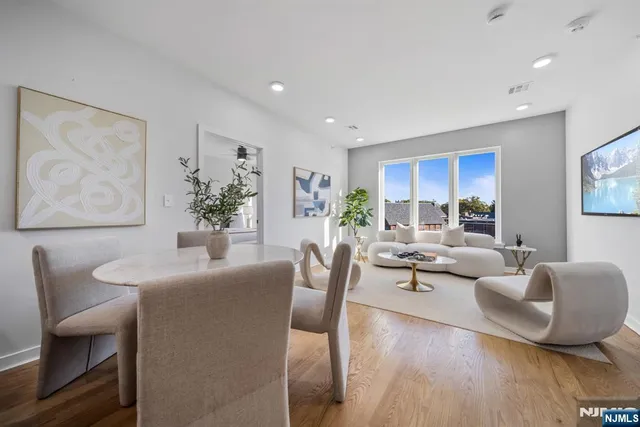 a living room with furniture wooden floor and a large window